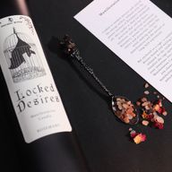 Kadar izbliza etikete svijeće Locked Desires sa šišmišem u kavezu.